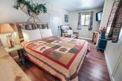 a bedroom with a bed and a chair at Fawn Valley Inn- Cabana apts in Estes Park
