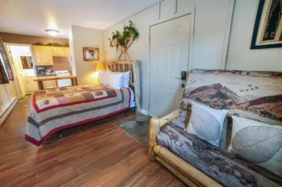a bedroom with a bed and a couch in it at Fawn Valley Inn- Cabana apts in Estes Park