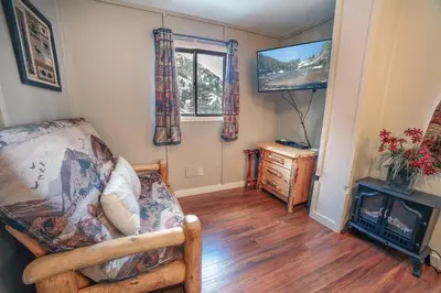 a living room with a couch and a television at Fawn Valley Inn- Cabana apts in Estes Park