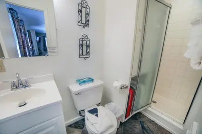 a white bathroom with a toilet and a shower at Fawn Valley Inn- Cabana apts in Estes Park