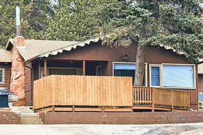 a house with a wooden fence in front of it at Lazy R Cottages- 9 cabin in Estes Park