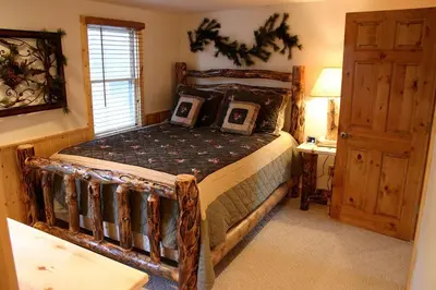a bedroom with a wooden bed in a room at Lazy R Cottages- 9 cabin in Estes Park