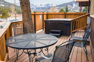 a table and chairs on a deck with a tree at Lazy R Cottages- 9 cabin in Estes Park