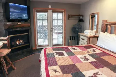 a bedroom with a fireplace and a bed with a quilt at Fawn Valley Inn- 254 apts in Estes Park