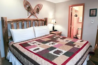 a bedroom with a bed with a quilt on it at Fawn Valley Inn- 254 apts in Estes Park