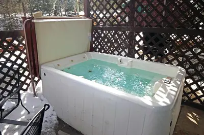 a white bath tub filled with blue water at Fawn Valley Inn- 254 apts in Estes Park