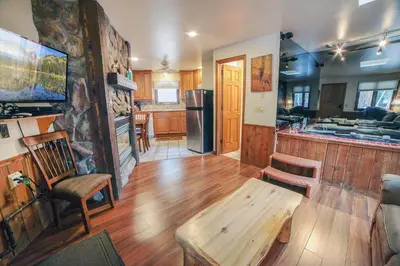 a living room with a wooden floor and a kitchen at Sunnyside Knoll- 5 cabin in Estes Park
