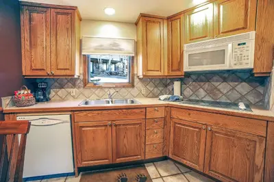 a kitchen with wooden cabinets and a sink at Sunnyside Knoll- 5 cabin in Estes Park