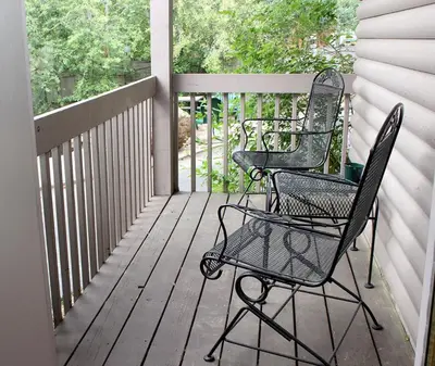 two lawn chairs sitting on a porch with a fence at Sunnyside Knoll- 5 cabin in Estes Park