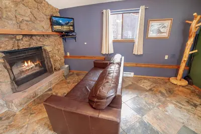 a living room with a couch and a fireplace at Timber Creek Chalets- 7 cabin in Estes Park