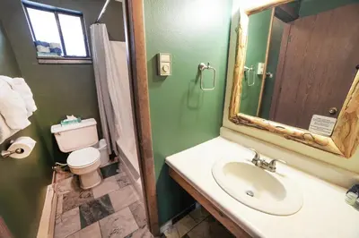 a bathroom with a sink and a toilet and a mirror at Timber Creek Chalets- 7 cabin in Estes Park