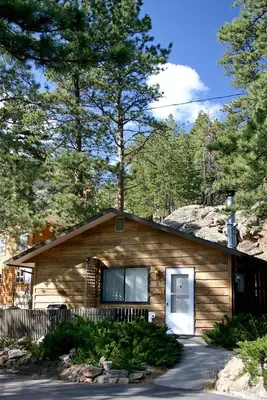 a small wooden house in the middle of trees at Timber Creek Chalets- 7 cabin in Estes Park