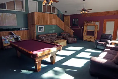 a living room with a pool table and a staircase at Timber Creek Chalets- 7 cabin in Estes Park
