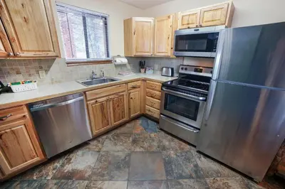 a kitchen with wooden cabinets and stainless steel appliances at Timber Creek Chalets- 7 cabin in Estes Park