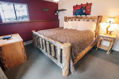 a bedroom with a bed with a wooden bed frame at Timber Creek Chalets- 7 cabin in Estes Park