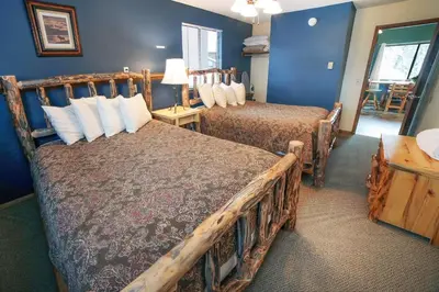 two beds in a room with blue walls at Timber Creek Chalets- 7 cabin in Estes Park