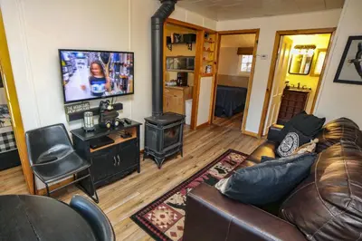 a living room with a couch and a stove at Lazy R Cottages- 5 cabin in Estes Park