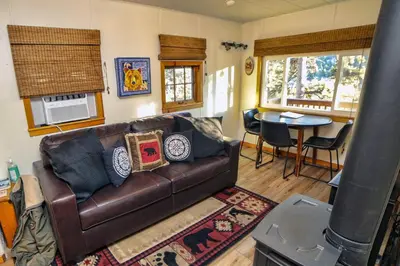 a living room with a leather couch and a table at Lazy R Cottages- 5 cabin in Estes Park