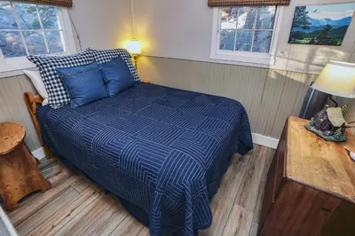 a bedroom with a blue bed in a room at Lazy R Cottages- 5 cabin in Estes Park