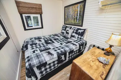 a small bedroom with a bed and a table at Lazy R Cottages- 5 cabin in Estes Park