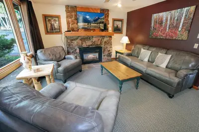 a living room with leather furniture and a fireplace at Sunnyside Knoll- 7 cabin in Estes Park