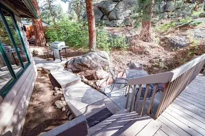 a porch with a bench and a rock at Sunnyside Knoll- 7 cabin in Estes Park