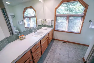 a bathroom with a sink and a large mirror at Sunnyside Knoll- 7 cabin in Estes Park