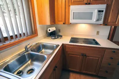 a kitchen with a sink and a microwave at Sunnyside Knoll- 8 cabin in Estes Park