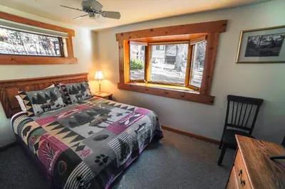 a bedroom with a bed and a desk and a window at Sunnyside Knoll- 8 cabin in Estes Park