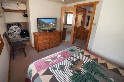 a bedroom with a bed and a television on a dresser at Sunnyside Knoll- 8 cabin in Estes Park