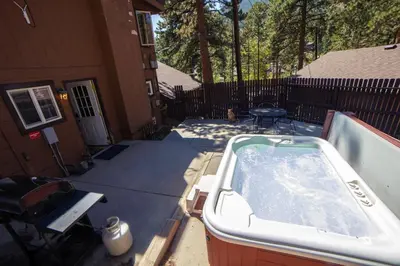 a hot tub on a patio next to a house at Timber Creek Chalets- 3 chalet in Estes Park