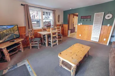 a living room with a wooden table and a table and chairs at Lawn Lane A - #3382 in Estes Park