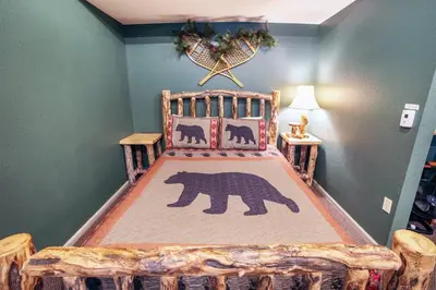 a bedroom with a bed with a bear blanket at Fawn Valley Inn- 104 condo in Estes Park