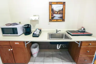 a kitchen counter with a sink and a microwave at Fawn Valley Inn- 104 condo in Estes Park