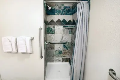 a shower with a glass door in a bathroom at Fawn Valley Inn- 104 condo in Estes Park