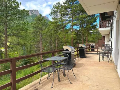 a patio with tables and chairs on a balcony at Fawn Valley Inn- 104 condo in Estes Park