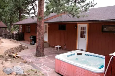 a small house with a hot tub in the yard at Timber Creek Chalets- 14 chalet in Estes Park