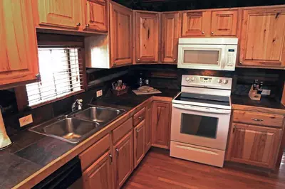 a kitchen with wooden cabinets and stainless steel appliances at Triple R Cottages- 8 cabin in Estes Park