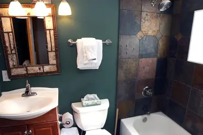 a bathroom with a sink and a toilet and a mirror at Triple R Cottages- 8 cabin in Estes Park