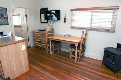 a kitchen with a table and a person taking a picture at Triple R Cottages- 2 cabin in Estes Park