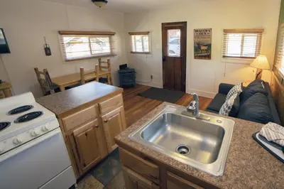 a kitchen with a sink and a living room at Triple R Cottages- 2 cabin in Estes Park