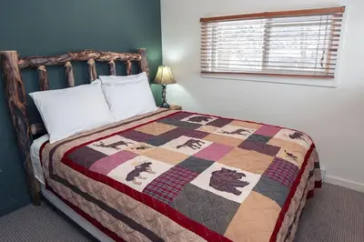 a bedroom with a bed with a quilt on it at Triple R Cottages- 2 cabin in Estes Park