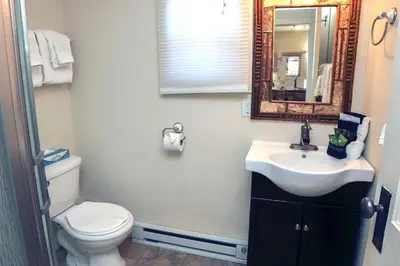 a bathroom with a toilet and a sink and a mirror at Triple R Cottages- 2 cabin in Estes Park