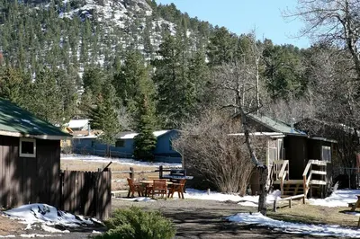 a cabin with a table and chairs in the snow at Triple R Cottages- 2 cabin in Estes Park