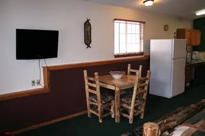 a kitchen with a small table and a refrigerator at Timber Creek Chalets- 11 chalet in Estes Park