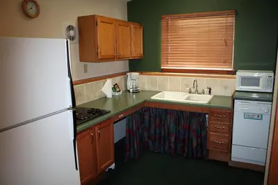 a kitchen with a white refrigerator and a sink at Timber Creek Chalets- 11 chalet in Estes Park