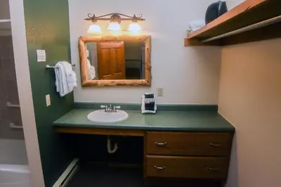 a bathroom with a sink and a mirror at Timber Creek Chalets- 11 chalet in Estes Park