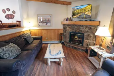 a living room with a couch and a fireplace at Sunnyside Knoll- 9 cabin in Estes Park