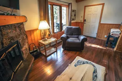 a living room with a chair and a fireplace at Sunnyside Knoll- 9 cabin in Estes Park