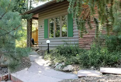 a house with a green window and a sidewalk at Sunnyside Knoll- 9 cabin in Estes Park